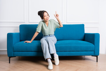 image of young Asian girl sitting on sofa at home