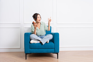 image of young Asian girl sitting on sofa at home