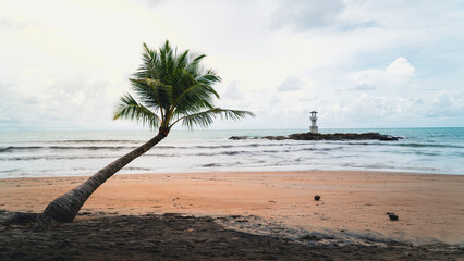 Strand mit Palme und Leuchtturm in Thailand