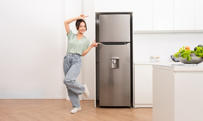 Asian woman standing next to the refrigerator in the kitchen