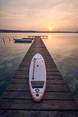 SUP board on a jetty on lake at sunset in Varna, Bulgaria.