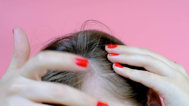 Girl touching her hair close-up on pink background , hair loss concept.