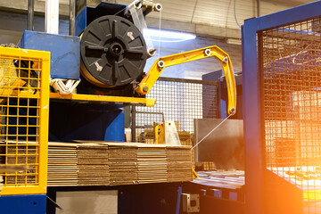 Ready-made cardboard boxes are moved in stacks along an automated packaging line. The strapping...