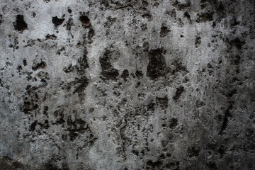 A weathered concrete wall with cracks and peeling paint, showing signs of age and decay.