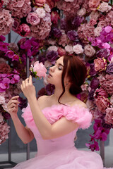 Girl in a pink dress on a background of flowers