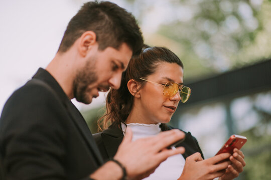Close up of  business partners looking at theis phones