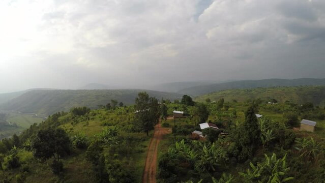 Aerial above Rwandan remote village on top of green rain forested mountain