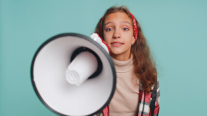 Hurry up. Young teenager child girl kid talking with megaphone, proclaiming news, loudly announcing advertisement, warning using loudspeaker to shout speech. Preteen children on studio blue background