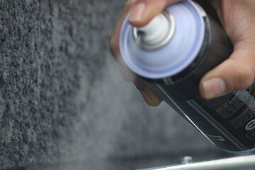 Closeup of man painting a fence with spray paint or aerosol paint