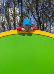  portrait of a todler boy at the playground on a sunny spring day with space for text