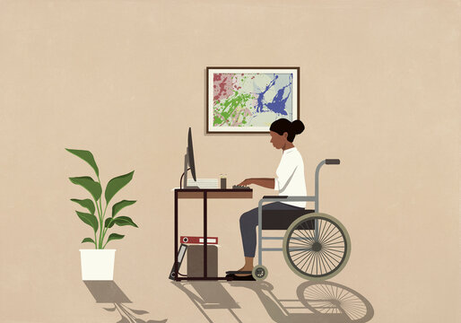 Woman in wheelchair working at computer in home office
