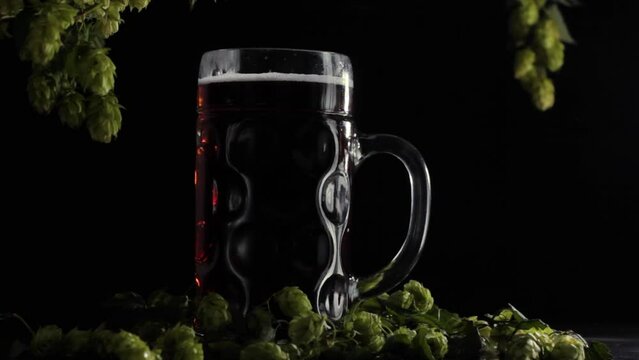 static video frame with a full beer glass on a wooden background with hops