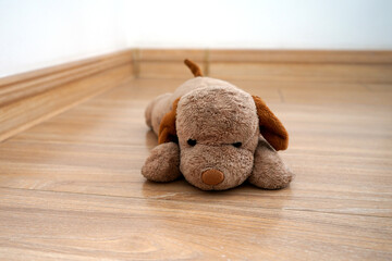 drizzle, the fluffy stuffed dog on the wooden floor