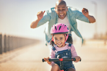 Excited father teaching girl to ride a bike in sunshine, summer fun and beach promenade outdoors....