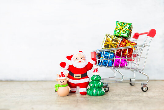 Christmas shopping concept, Santa clause with gift boxes in shopping cart with space on blurred background