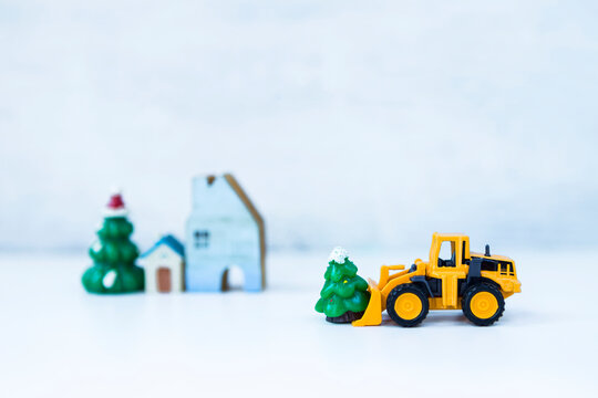 Front loader truck moving Christmas tree over blurred background, Festive season time
