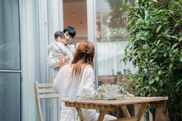 おうちのテラスで赤ちゃんと過ごす家族