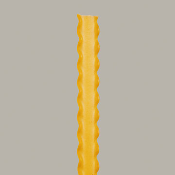 Close up still life raw reginette pasta noodle on gray background
