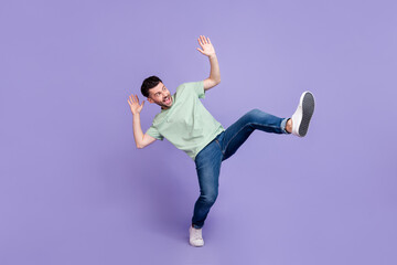 Fototapeta na wymiar Full length photo of crazy astonished man wear trendy clothes jeans look up empty space afraid scared isolated on purple color background