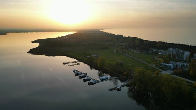 Marina with moored boats in lake Jamno and Baltic sea divided by spit on which lie the resorts