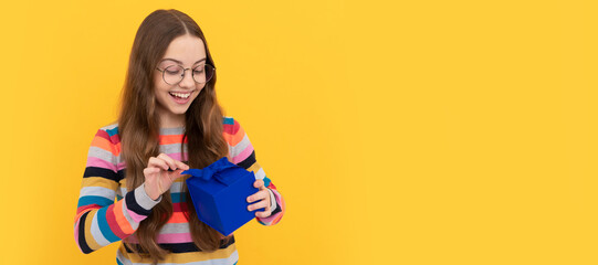 amazed kid in eyeglasses open present box for holiday, amazement. Kid girl with gift, horizontal poster. Banner header with copy space.