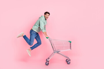 Full length photo of funky client wear trendy clothes walk empty space market hold pushcart cool...