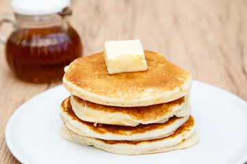 Fototapeta na wymiar Stack of freshly made buttermilk pancakes with maple syrup and butter 