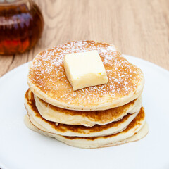 Stack of freshly made buttermilk pancakes with maple syrup and butter 
