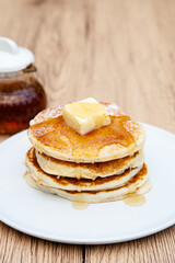 Stack of freshly made buttermilk pancakes with maple syrup and butter 