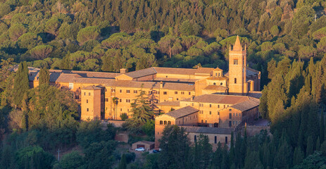 Sunrise view of the Abbey of Monte Oliveto Maggiore, a large Benedictine monastery in Tuscany, Italy - obrazy, fototapety, plakaty