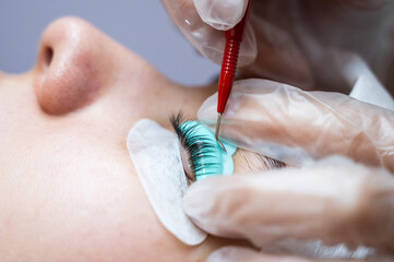 The master uses a multifunctional tool for laminating eyelashes.