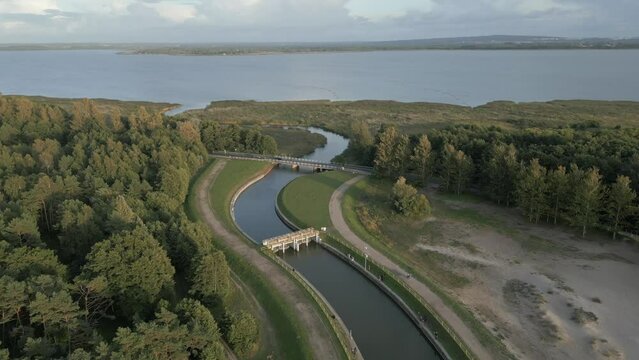 Aerial footage of canal and bridge between lake Jamno and Baltic sea in Uniescie, Mielno, Poland