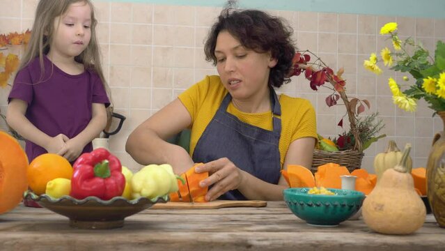 Thanksgiving Tradition, Pumpkin Pie Cooking. Happy mother and child cooks pumpkin pie for harvest festival. Festive dinner cooking with family