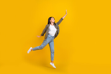 Full length photo of young japanese businesswoman jumping air raise hand up look mockup want catch...