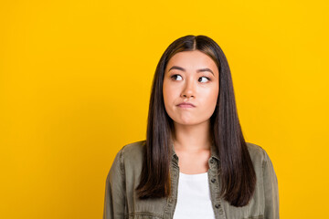 Portrait of good mood thoughtful girl with long hairstyle dressed khaki shirt look empty space isolated on yellow color background