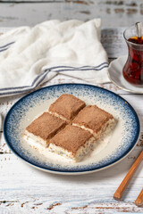 Cold baklava on a white wooden background. Baklava with milk and pistachio. Mediterranean cuisine delicacies. close up