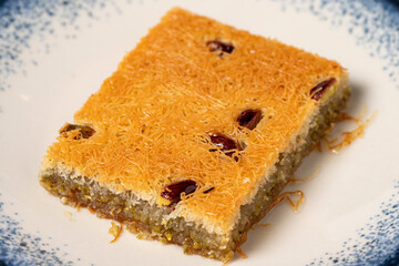 Kadayif with pistachio on a white wooden background. Mediterranean cuisine delicacies. close up