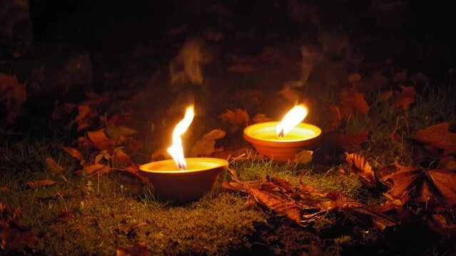Candle Flames on Cemetery an Night, All Saint's Day , Death Holiday Lantern, 1 November Candles, Fallen Leaves, Blurred Background