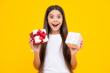 Emotional teenager child hold gift on birthday. Funny kid girl holding gift boxes celebrating happy New Year or Christmas. Excited teenager, glad amazed and overjoyed emotions.