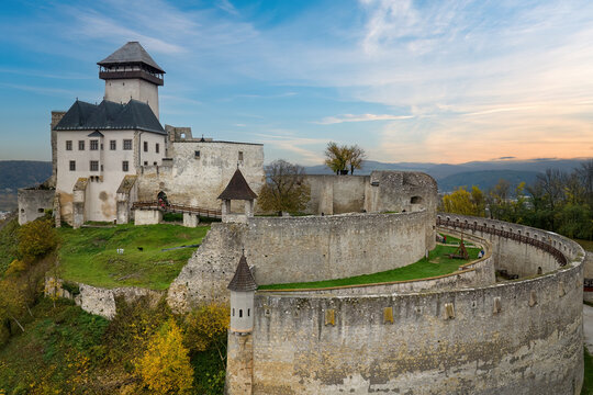 The mighty Trencin Castle in the colourful autumn landscape. Aerial view of the castle grounds against the blue sky. Travelling around Slovak castles and chateaus. Slovakia, Europe.