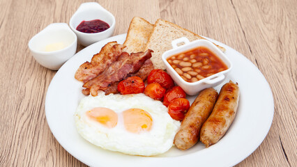 English breakfast set with fried egg, sausage, bacon, grilled tomato, baked bean and toast