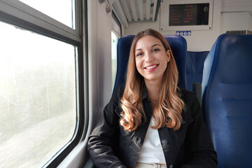 Portrait of young satisfied woman traveling with public transport sitting relaxed thoughtless. Looking at camera.