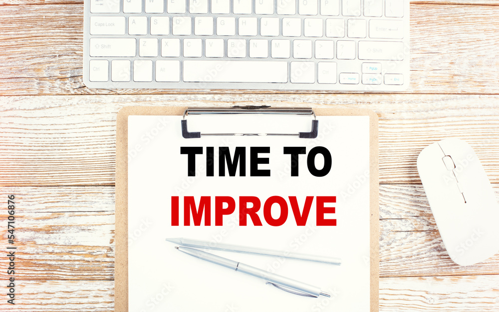 Poster time to improve text on a clipboard with keyboard on wooden background