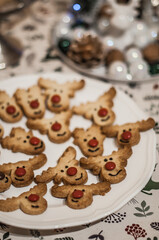 Cookies in the form of deer head with a red nose and a metal candlestick.