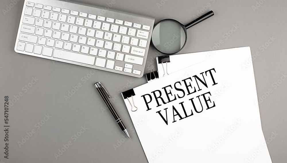 Poster present value text on paper with keyboard, magnifier and pen. business concept