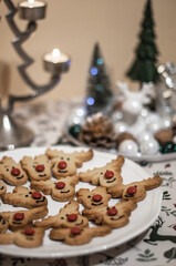 Cookies in the form of deer head with a red nose and a candlestick closeup.