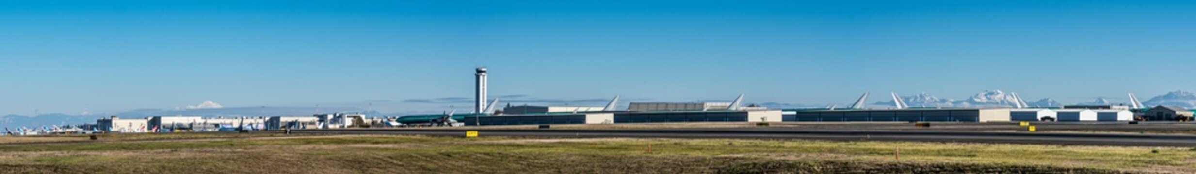 Everett, Washington, USA - November 2022, Paine Field runway, hangar and Tower environment with Boeing assembly line and parked Boeing Aircrafts around the Buildings - panoramic view