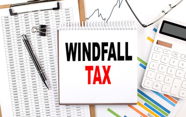 WINDFALL TAX text on notebook with chart, calculator and pen