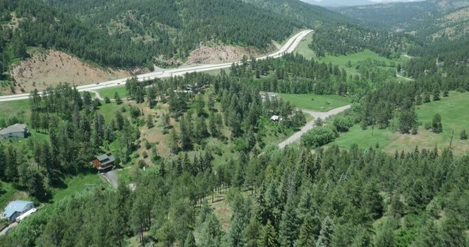 Aerial tilt up to reveal Highway 285 in Conifer, Colorado in summer near West Ranch