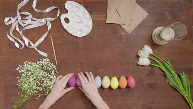 Top view of a table with items to create a composition for Easter. Women's hands arrange objects on the table. Church holiday-Easter